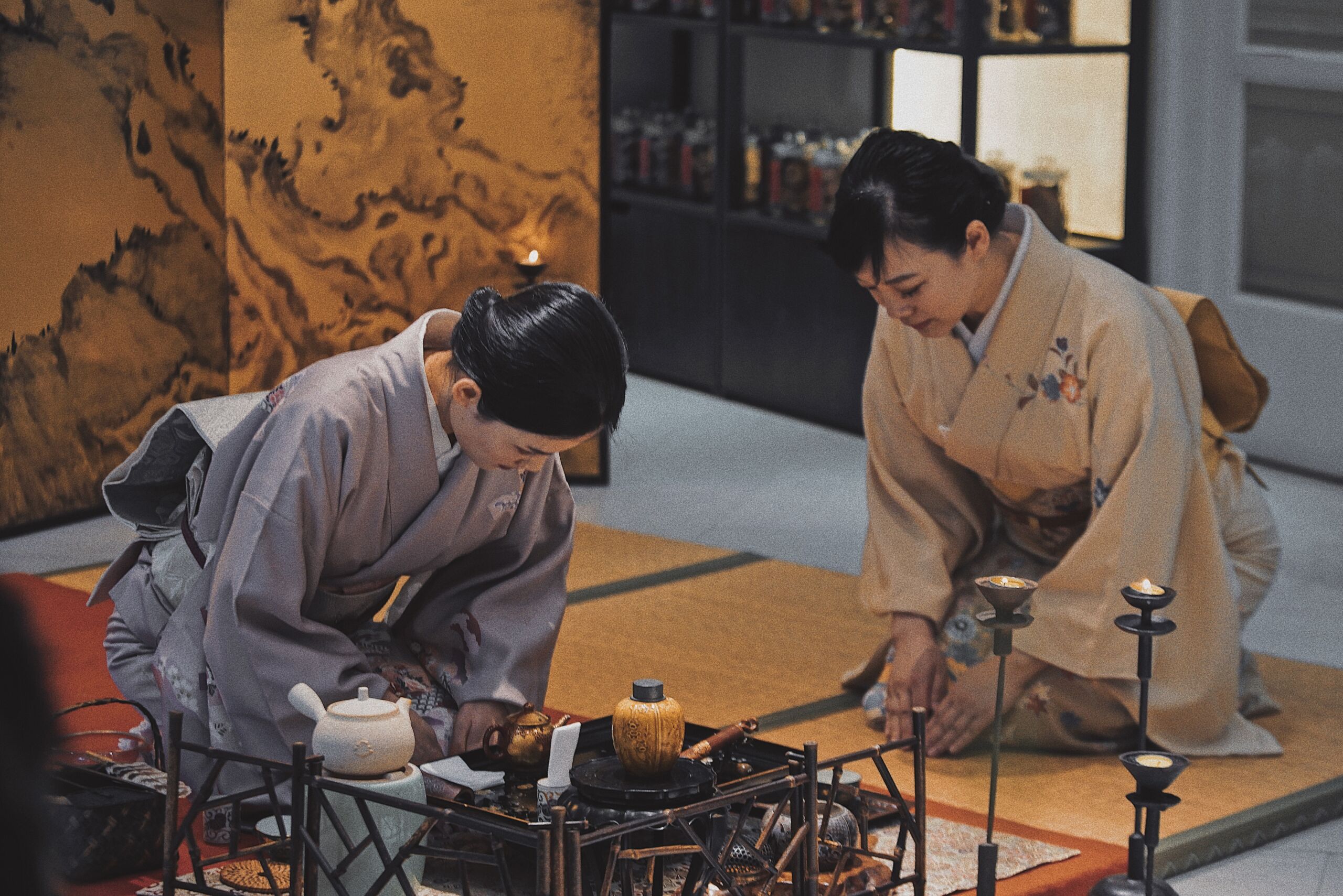 The Art of Japanese Hospitality Two women preparing tea in a traditional Japanese way, sitting on their knees in front of a low table