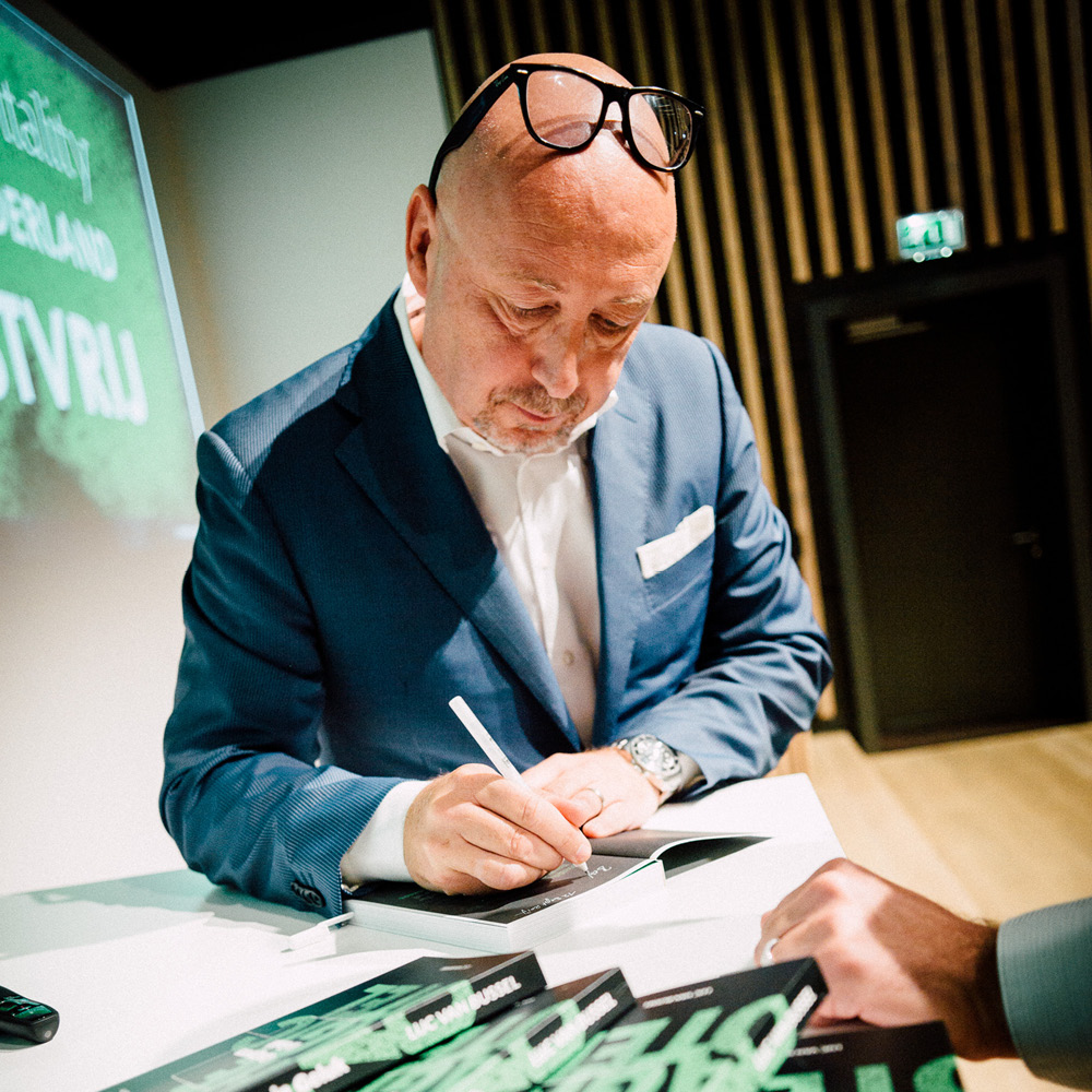 Luc van Bussel als schrijver signeert zijn boek Gastgevers in Geluk